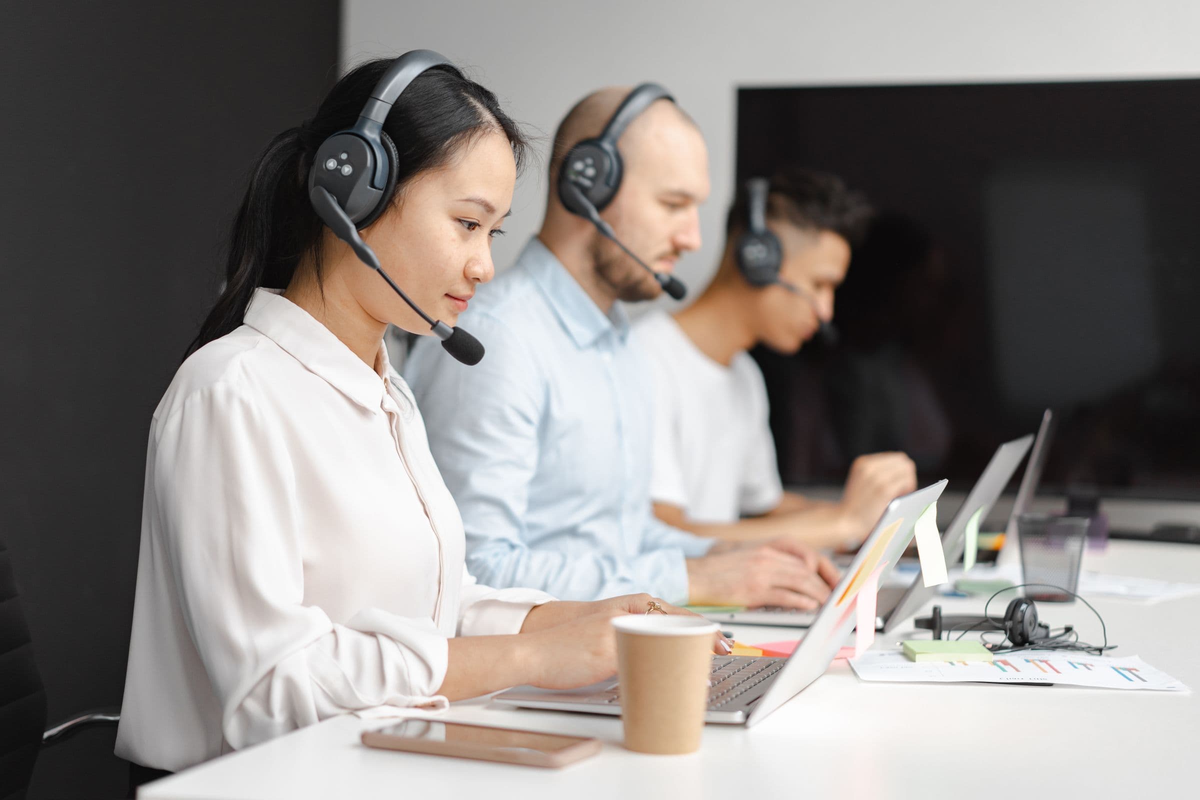 Support agents at laptops answering customer questions