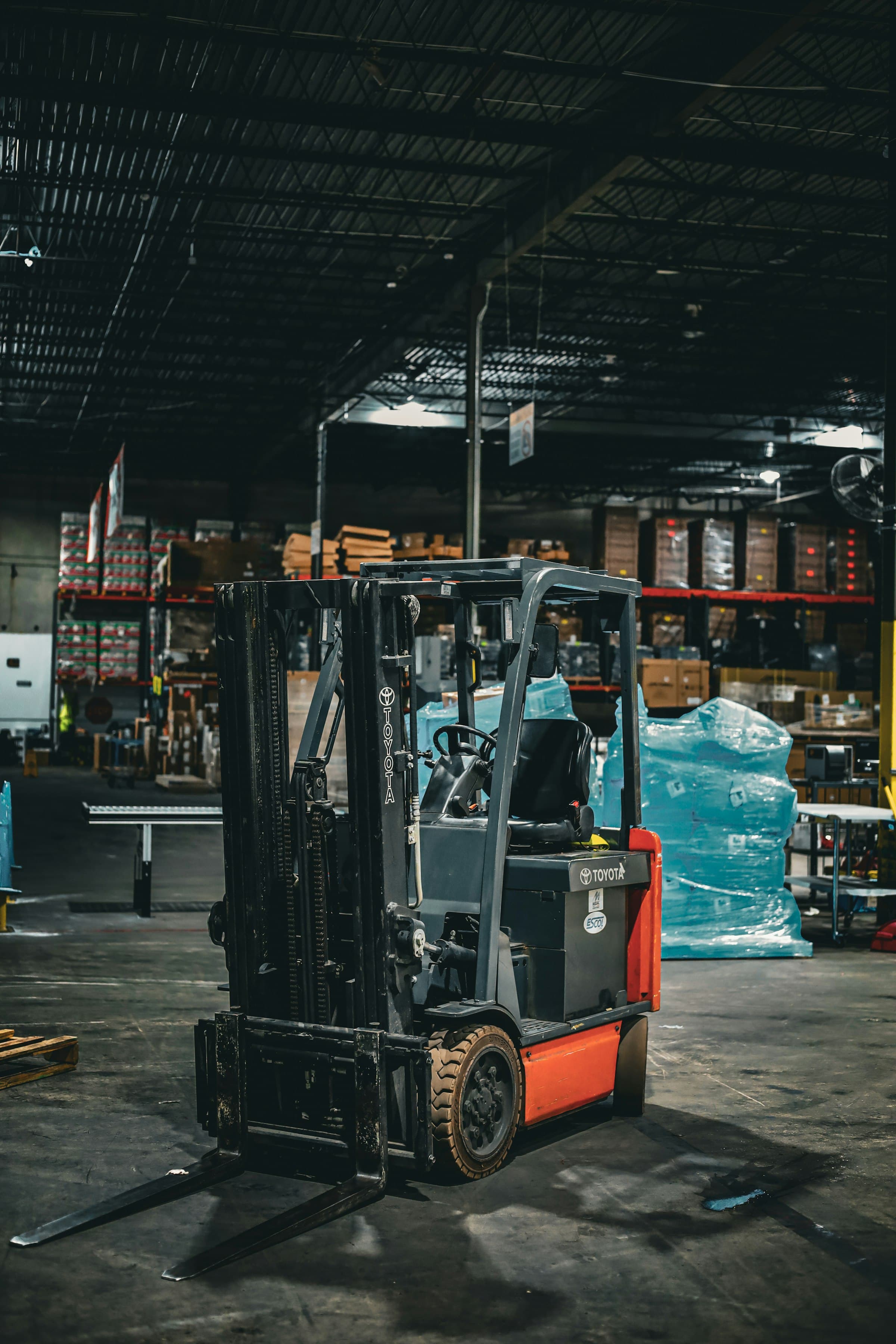 A forklift staged in a warehouse aisle, ready to move freight