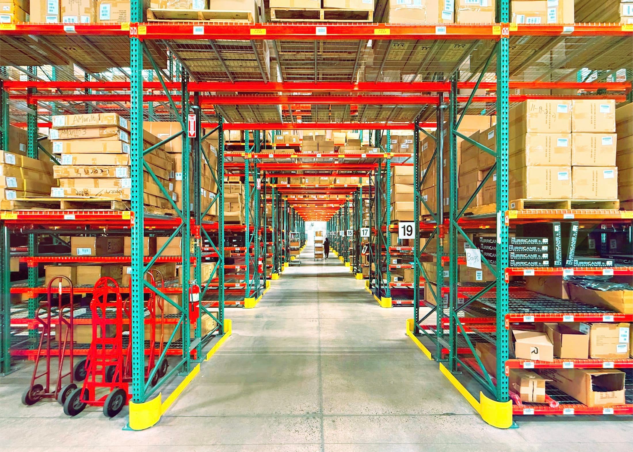 Warehouse aisle with tall shelving stocked with inventory